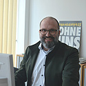 Lars Hartwig, Vorsitzender des Gesamtpersonalrats; im Hintergrund ein Plakat: Fremdenhass - ohne uns