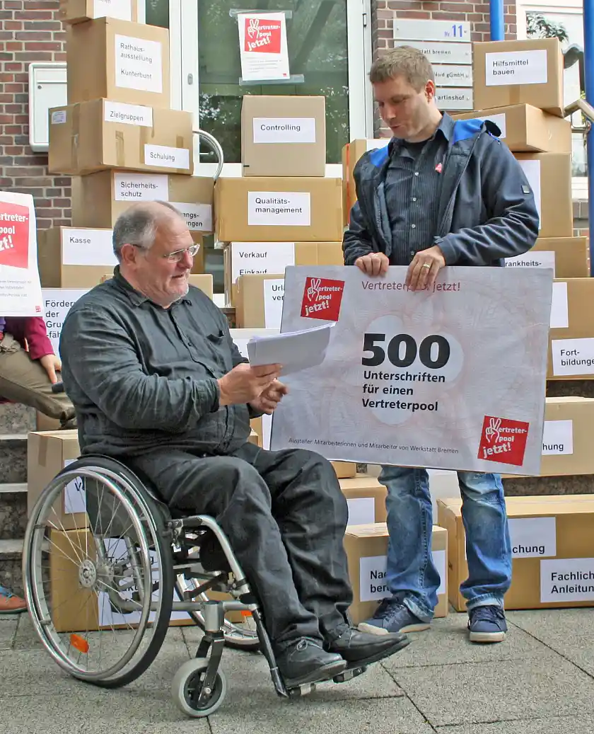 Jörn Kroppach überreicht einen "Scheck" mit 500 Unterschriften Herrn Staatsrat Frehe