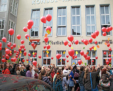 Menschen lassen rote Luftballons in die Luft steigen
