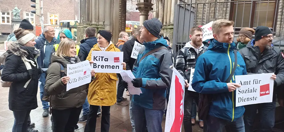 Teilnehmer:innen der Protestaktion mit Pappschildern