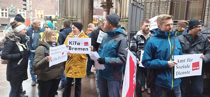 Teilnehmer:innen der Protestaktion mit Pappschildern