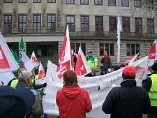 Beschäftigte mit Fahnen und Transparenten auf dem Platz vor der Senatorin für Finanzen