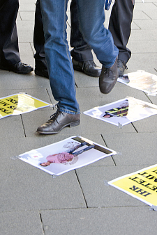 Füße treten auf am Boden liegende Fotos von Beschäftigten