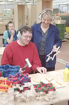 Beschäftigter produziert in der Werkstatt Holzsterne