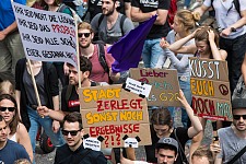 Protestierende Menschen mit Plakten und Transparenten
