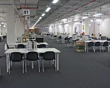 großer Raum mit vielen Schreibtischen, auf denen Bildschirme stehen