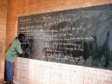 Kinder schreibt an der Schultafel