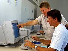 Dozentin und Fortbildungsteilnehmer vor einem Bildschirm