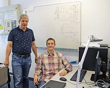 Porträt von Torsten Radeke mit einem Auszubildenden, der von dem PC sitzt