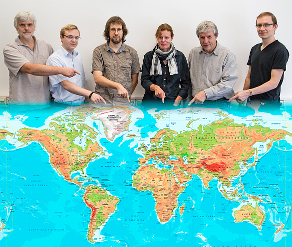 6 Menschen zeigen auf eine Weltkarte