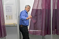 Martin Kesper steht in einer der Wahlkabinen