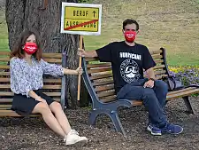 Zwei von der Jugend- und Ausbildendenvertretung im Gesamtpersonalrat sitzen auf zwei Bänken, mit Abstand