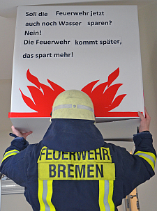 Feuerwehrmann hält Plakat hoch