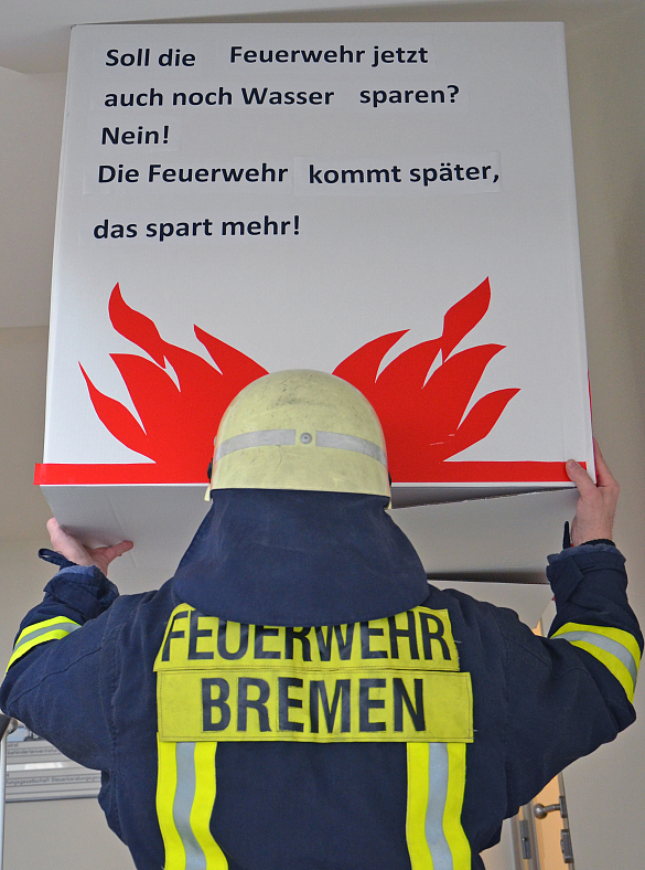 Feuerwehrmann hält Plakat hoch