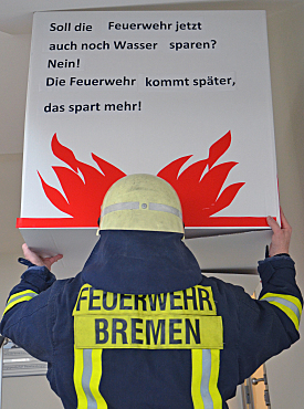 Feuerwehrmann hält Plakat hoch