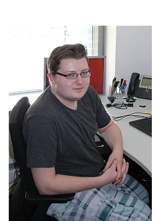 Porträt von Eric Schädler am PC sitzend