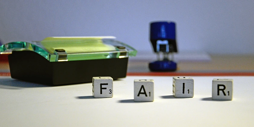 Foto, auf dem die Buchstabenwürfel das Wort FAIR bilden