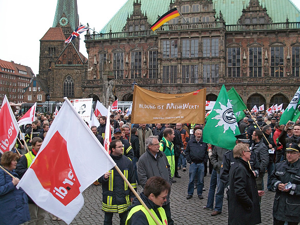 Beamtinnen und Beamte auf dem Bremer Marktplatz mit Fahnen und Transparenten