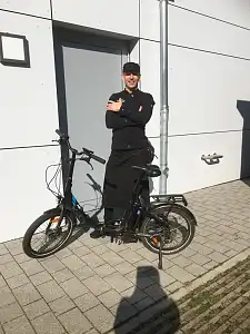 Friedrich Peters in Arbeitskleidung mit seinem E-Fahrrad