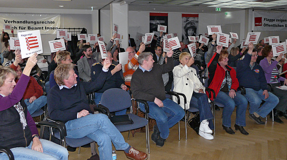 Teilnehmer halten Pappe hoch mit dem Bild der Bremer Flagge und dem Schriftzug 'Flagge zeigen'