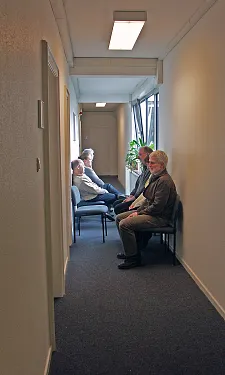 Enger Flur mit sitzendem Publikum