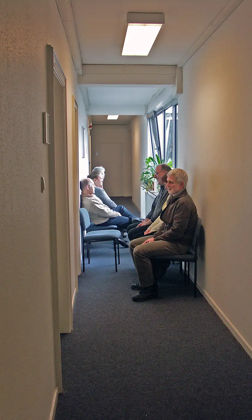 Enger Flur mit sitzendem Publikum