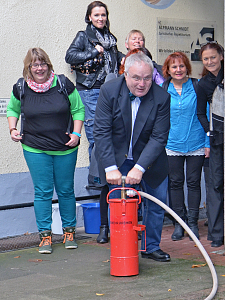 Staatsrat Henning Lühr pumpt das Wasser in das Handlöschgerät