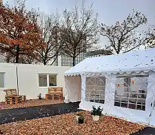 Das Bild zeigt Container und ein Zelt in herbstlicher Umgebung.