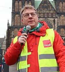 Markus Westermann mit einem Mikrofon auf dem Bremer Marktplatz