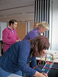 FortbildungsteilnehmerInnen bauen an einer Brücke 
