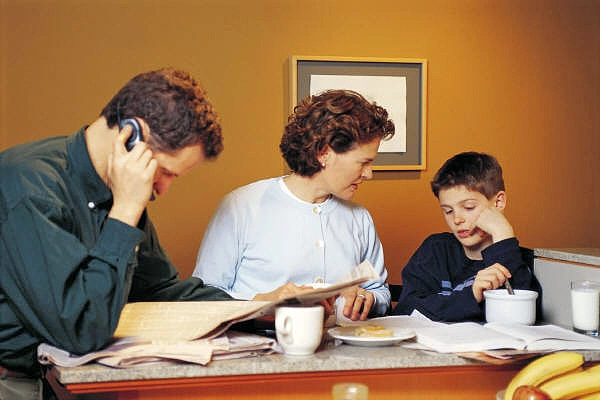Mutter, Vater und Kind sitzen an einem Tisch