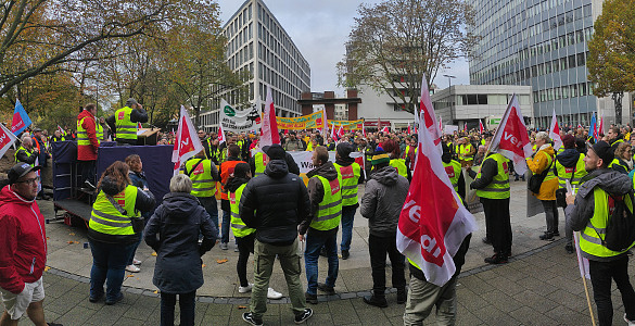 Hunderte Streikende, viele mit gelben Westen und Gewerkschaftsfahnen, haben sich auf dem Rudolf-Hilferding-Platz versammelt.
