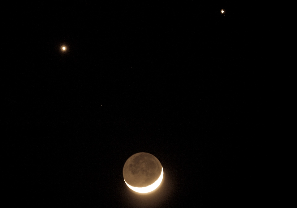 Halbmond mit zwei Sternen im dunklen Nachthimmel