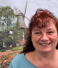 Porträt von Sandra Kitzmann mit der Wallmühle im Hintergrund.
