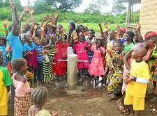 Viele Kinder stehen um eine neue Wasserzapfanlage und freuen sich