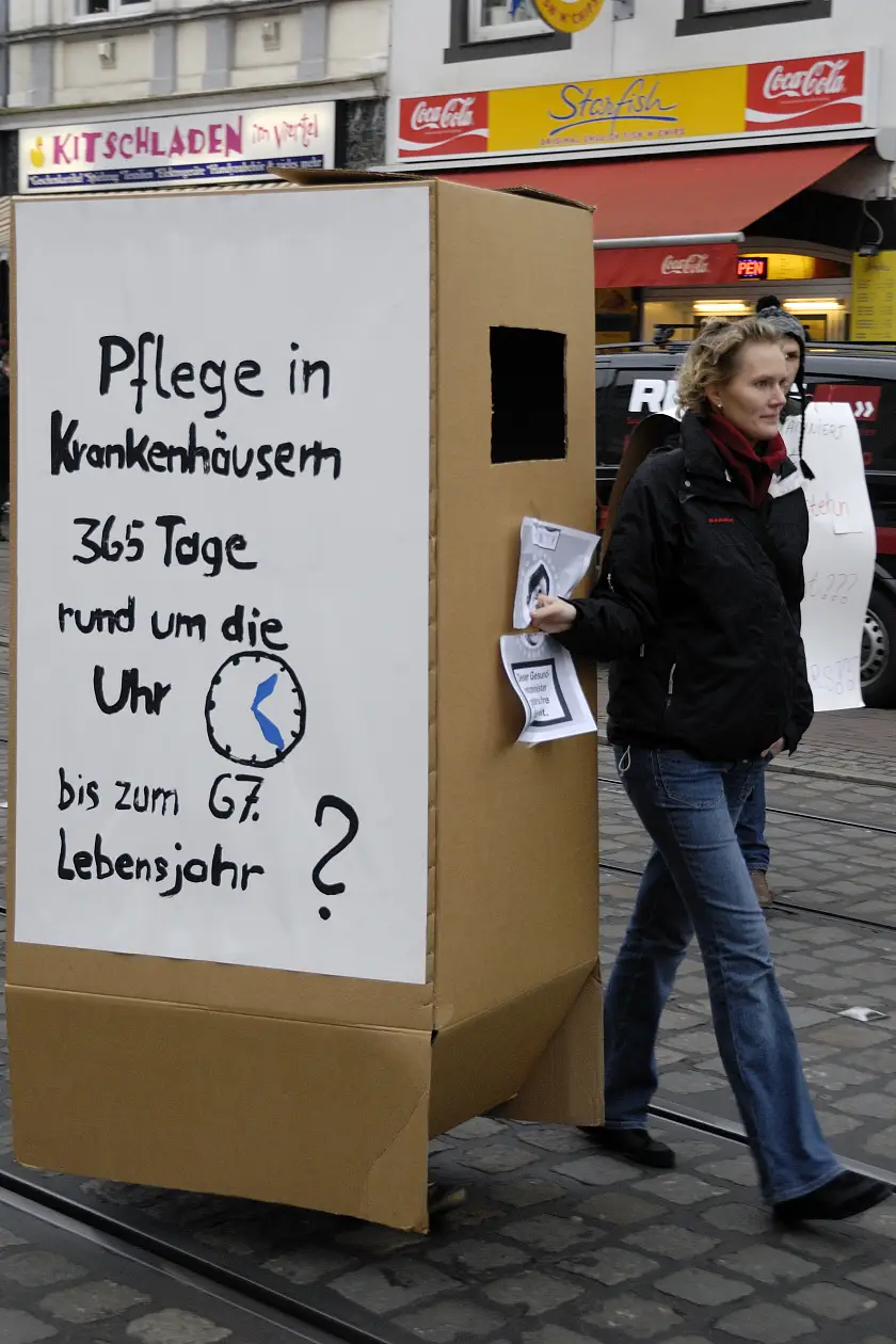 Kollegin auf Demonstration mit Pappkarton zum Thema Rente mit 67