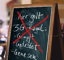 Eine Tafel, auf der die 3g-Regel durchgestrichen ist.