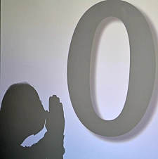 Schatten einer Person, die eine große schwarze Null anbetet.