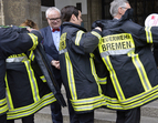 Von der Feuerwehr erhalten Karoline Linnert und Carsten Sieling Uniformen, damit sie an Wochenenddiensten teilnehmen können.