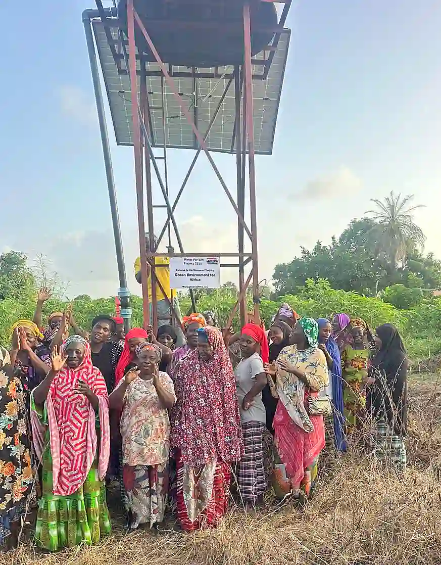 G&auml;rtnerinnen stehen vor dem Brunnen mit Solarmodul